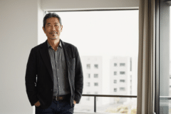 明るい室内で落ち着いた表情を見せる50代の日本人男性